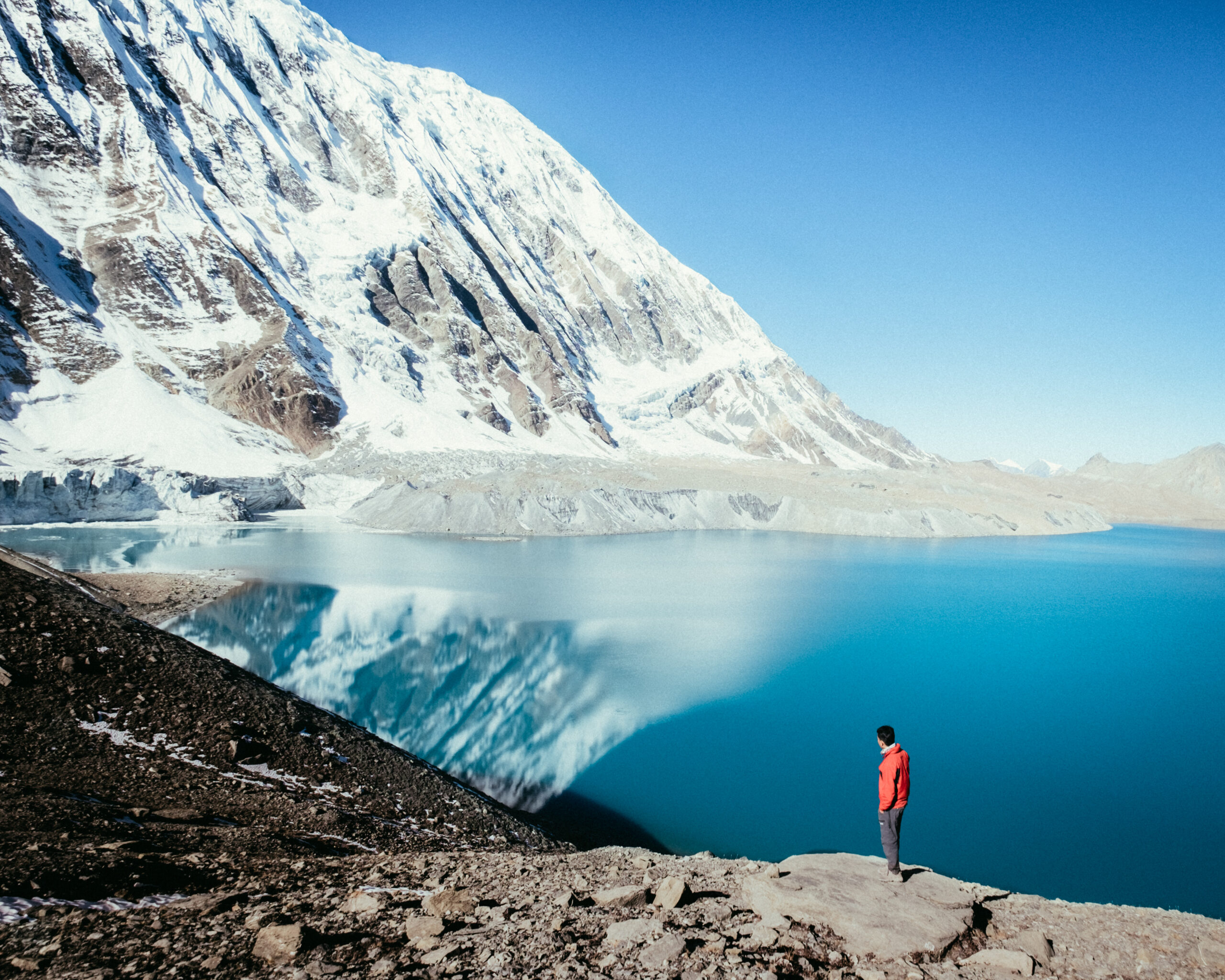 Pristine turquoise alpine lake reflecting high mountain peaks